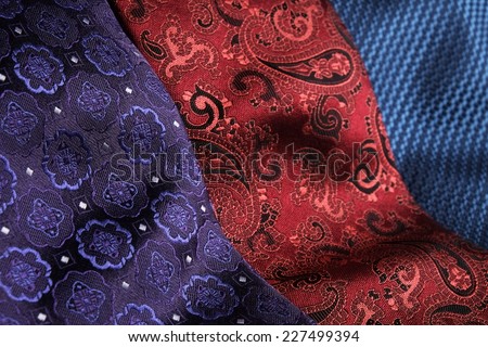 Set of rolled up silk ties close to each other, side-by-side. Blue, red, bordeaux, black and purple