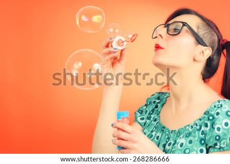 Pretty lady blowing colorful bubbles