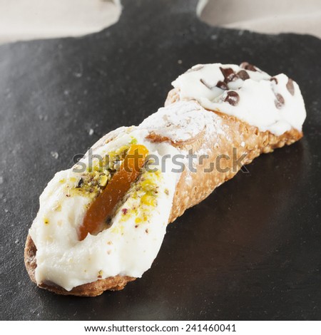 Cannolo over a black stone background, square image