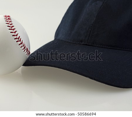 A baseball near a baseball hat