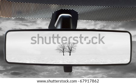 Winter landscape, reflected in the rearviewmirror of a car