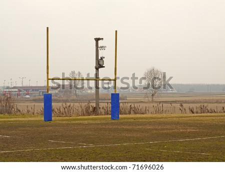 Rugby poles in a rugby field, with tree in the background