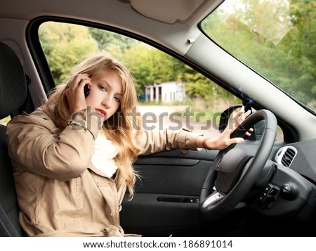 smoking young businesswoman  driving a car and speaking on the phone
