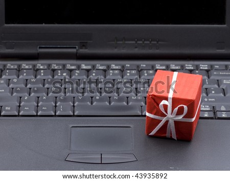 small red gift box with bright ribbon on laptop keyboard