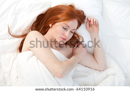 beautiful young woman relaxing in white bedding