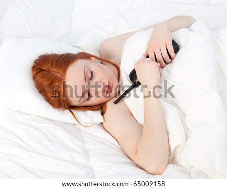 lying woman with phone in white bedding