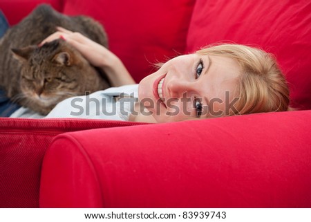 lying on red sofa young woman with cat