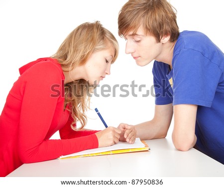 Young couple students studying together at table with clipboard