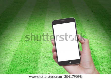 Man hand holding mobile smart phone with blank screen,football stadium background