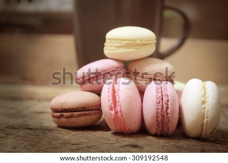 Colorful french macaroons and cup coffee on wooden,vintage style