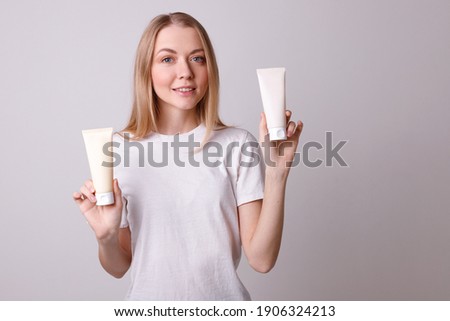Smiling girl in a white T-shirt holding a cosmetics container Foto stock © 