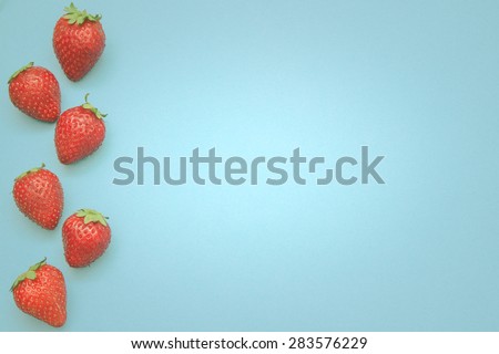 Some strawberries in line with a lot of copy space for your text or editing.
