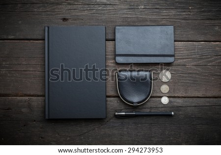 Style black mans accessories, dairy, wallet, pencil, notebook on old black wooden desk.