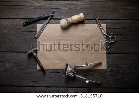 The table with set of vintage shaving tools and sheet of kraft paper