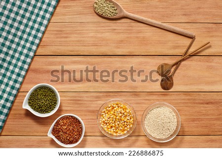 Lentils Rice Beans Corn and Sesame seeds in a white Bowl and wooden spoon on wood background with a Table Cloth. Healthy grain food selection with Text Space
