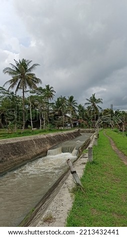 the calm beautiful atmosphere of the van der wijck canal, with lush green banks, sluices and waterfalls, and bridges. the upstream area of the mataram ditch that irrigates Yogyakarta's agriculture Stock fotó © 