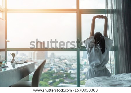 Work-life balance city living quality concept with happy Asian girl lifestyle having good day morning waking up from sleep  taking some rest, lazily relaxing in comfort condominium or hotel bed room Stock foto © 