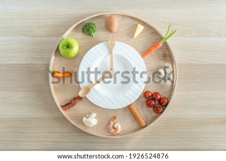Intermittent fasting IF and ketogenic diet concept with 8-hour clock timer for eating nutritional or keto LCHF low carb high fat food meal healthy dish and 16-hour skipping meal for weight loss