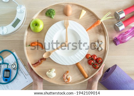 Intermittent fasting IF diet concept with 16:8 hour clock timer for skipping meal and eating keto low carb, high fat food meal healthy nutritional dish with gym exercise for body weight loss