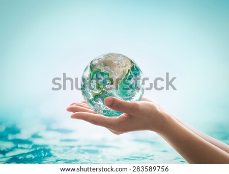 Isolated hands holding green planet on turquoise green water background : World ocean day and hydrography concept: Elements of this image furnished by NASA