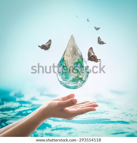 Butterfly drinking water from the green globe drop over human hands with clear turquoise blue background: Saving water / green environment protection concept: Elements of this image furnished by NASA