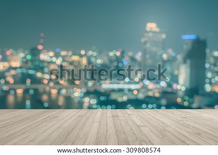 Wood floor in sepia brown grey color tone with blurred abstract background of Bangkok night lights downtown city view with bokeh in vintage style color tone: Wooden table with blur retro cityscape