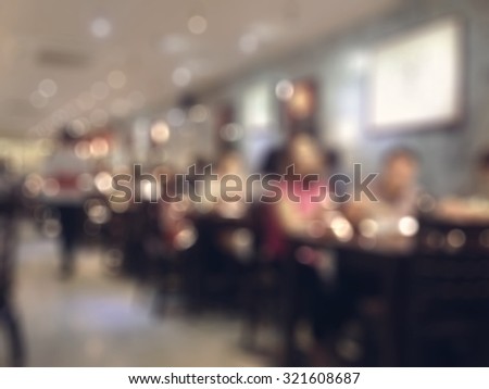 Blurred abstract background of people dinning in fine restaurant with tables and chairs for eating area on interior walkway: Blurry view inside Japanese food restaurant in vintage style color tone