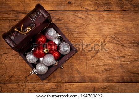 Small treasure box with Christmas decorations, wooden background