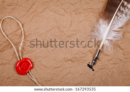 Picture of red wax seal and quill pen on crumpled old paper texture background.