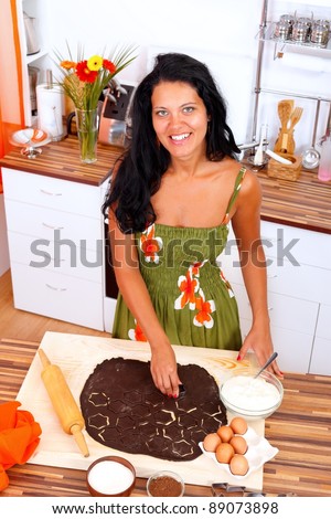 Smiling woman making cake in the kitchen