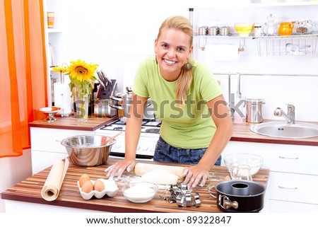 Lovely young woman making cake in the kitchen