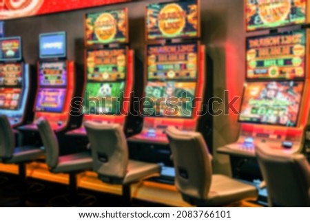 Defocused Illuminated neon Australia betting Slot machines, poker machines or pokies are officially termed gaming machines. Machines are found in casinos, pubs, and clubs in some states for Background