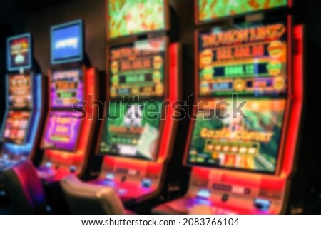 Defocused Illuminated neon Australia betting Slot machines, poker machines or pokies are officially termed gaming machines. Machines are found in casinos, pubs, and clubs in some states for Background