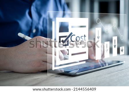 Cost reduction Concept. Businessman with his hand lowers the arrow of the graph. Cost text with a down arrow. budget, Cost Management. cut, lower. Stockfoto © 