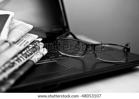 Newspapers laptop glasses in composition black and white