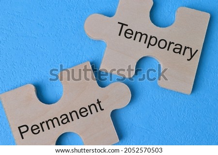 Wooden jigsaw puzzle with text TEMPORARY and PERMANENT Foto d'archivio © 
