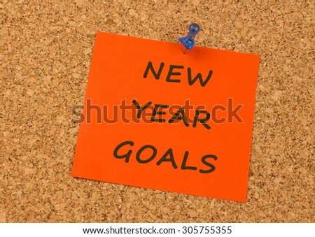 Orange sticky note on an office cork board - New Year Goals