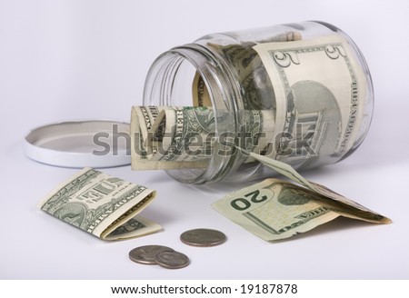 an open glass jar with money, banknotes and coins