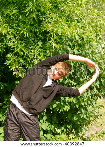 young man does warm-up in the open air