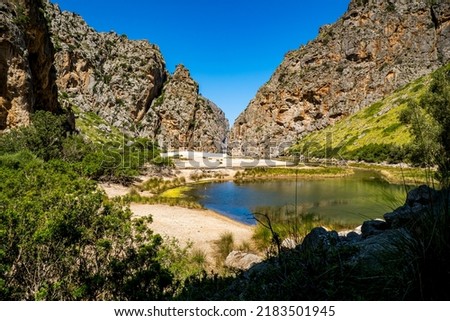 Panorama view of a valley with pond inside the deep gorge with riverbank of Torrent de Pareis mountain stream and the Cala de Sa Calobra beach in the background nearby Mallorca village of Sa Calobra. Foto stock © 