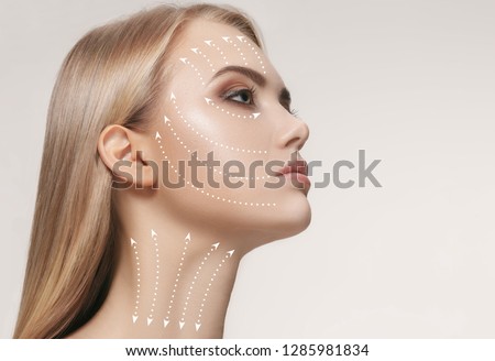 Close-up portrait of young, beautiful and healthy woman with arrows on her face. The spa, surgery, face lifting and skin care concept Foto stock © 