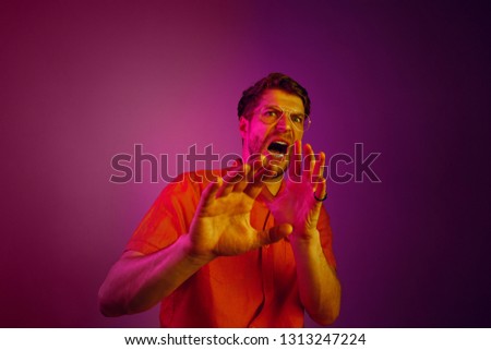 I'm afraid. Fright. Portrait of the scared man. Business man standing isolated on trendy pink studio background. Human emotions, facial expression concept. Neon, retro, synth wave and art style Сток-фото © 