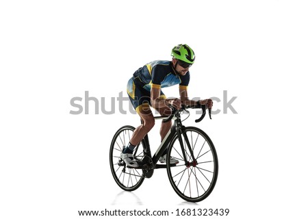 Triathlon male athlete cycle training isolated on white studio background. Caucasian fit triathlete practicing in cycling wearing sports equipment. Concept of healthy lifestyle, sport, action, motion. Сток-фото © 