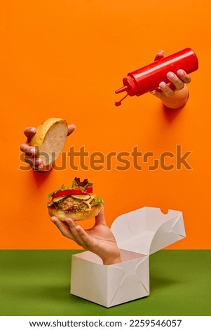 Foto Bild weibliche Hand ragt aus einem zerrissenen Loch in einem gelben Papierhintergrund, ein Teil des Körpers zeigt mit dem Zeigefinger nach oben. Leerzeichen kopieren