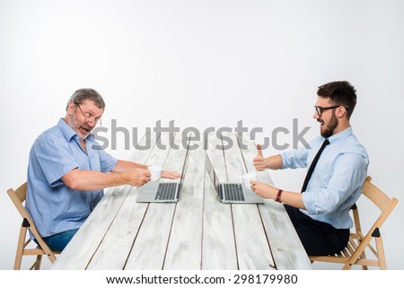 two colleagues working on project together on light gray background. They drinking coffee. happy man and jealous man. the concept of competition in the business