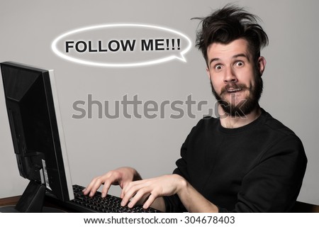 Funny and crazy blogger using a computer on gray background. man\'s hands on the keyboard. Follow Me request concept for social networking on internet