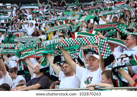 WARSAW, POLAND - APRIL 29: Fanatical fans of Legia cheer during the league football match between Legia Warsaw vs Jagiellonia Bialystok on April 29, 2012 in Warsaw, Poland. Final results: 1:1