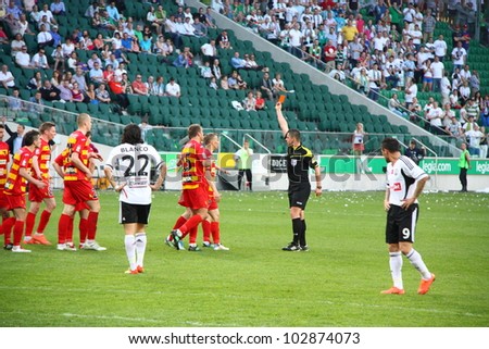 WARSAW, POLAND - APRIL 29: The referee shows a red card the Jagiellonia player during the match between Legia Warsaw vs Jagiellonia Bialystok on April 29, 2012 in Warsaw, Poland. Final results: 1:1