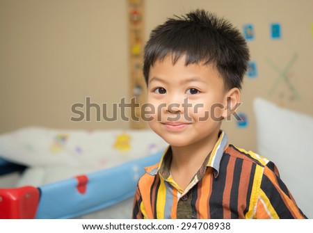 Handsome Boy smile in mildly manner in Baby room , Asian people