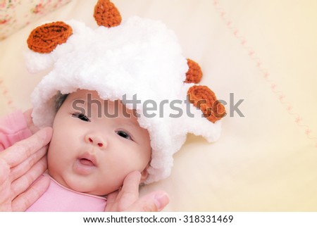 Cute Baby in baby cocoon or sleeping bag with her mather hand touch on face ,Vintage and soft picture style